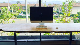A raw barkline edge on a solid wood desktop adds a rustic touch to your work area