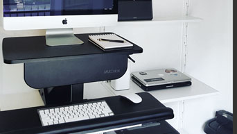 A sit-stand workstation is made possible with a standing desk converter